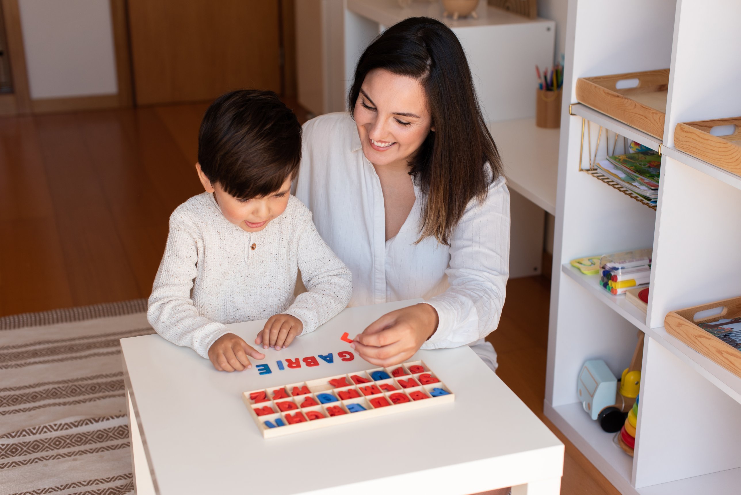 Educator helping a child spell with the movable alphabet